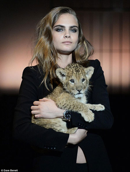 Cara Delevingne poses with a lion cub for TAG Heuer - Africa Geographic