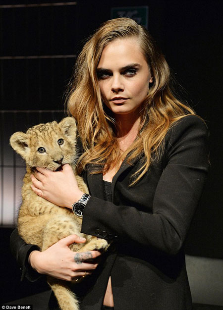 Cara Delevingne poses with a lion cub for TAG Heuer - Africa Geographic