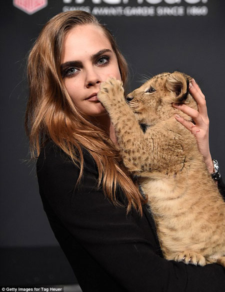 Cara Delevingne poses with a lion cub for TAG Heuer - Africa Geographic