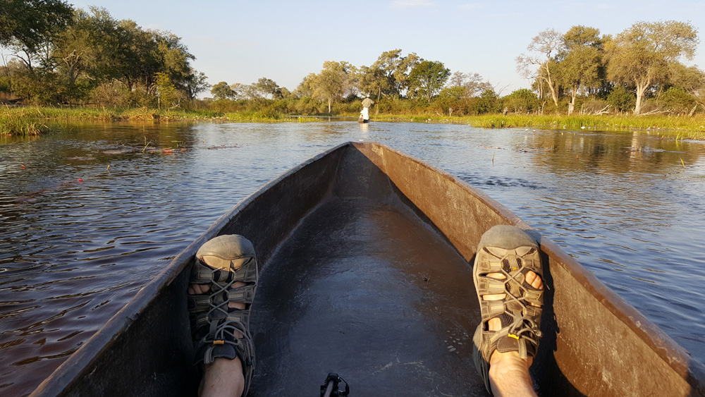 Feet in a mokoro while out on the waters of the Okavango Delta