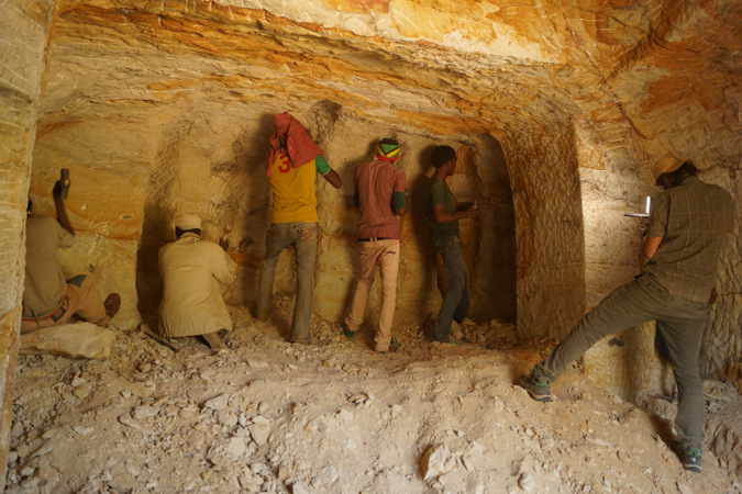 Team of chisellers working on a large piece of rock in Ethiopia