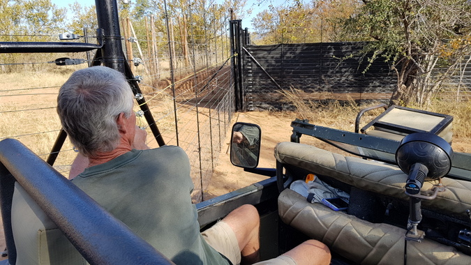 Person in safari vehicle about to open boma door