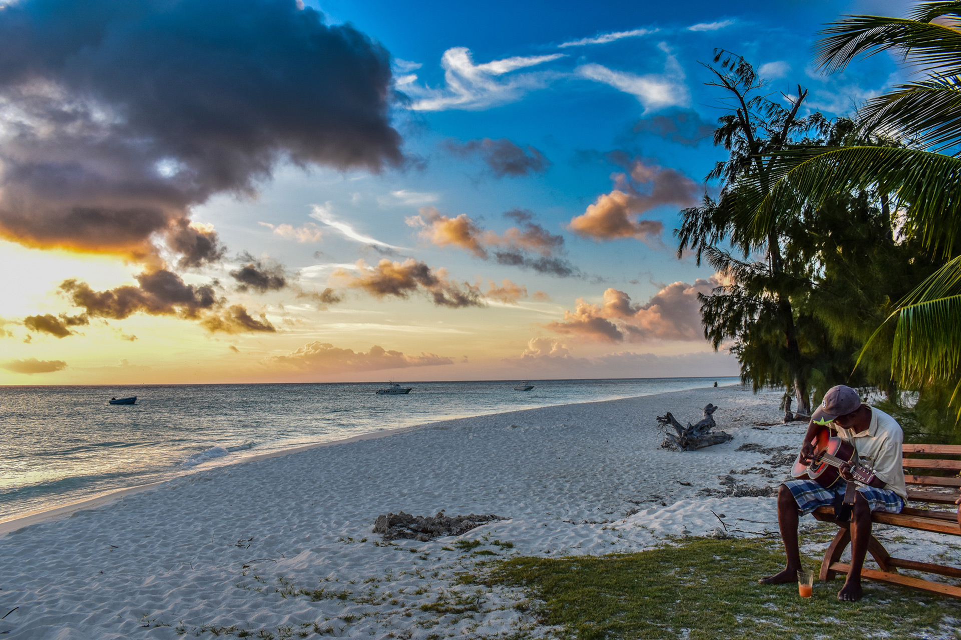 Man playing guitar on one of Aldabra's beaches in Seychelles