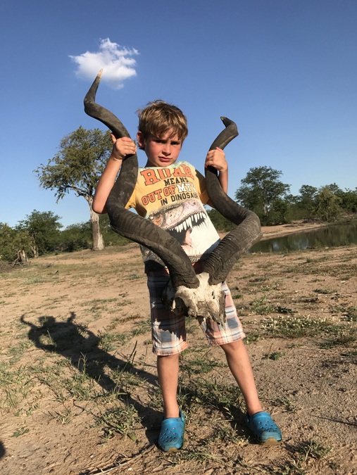 Kid with large antelope skull while on safari