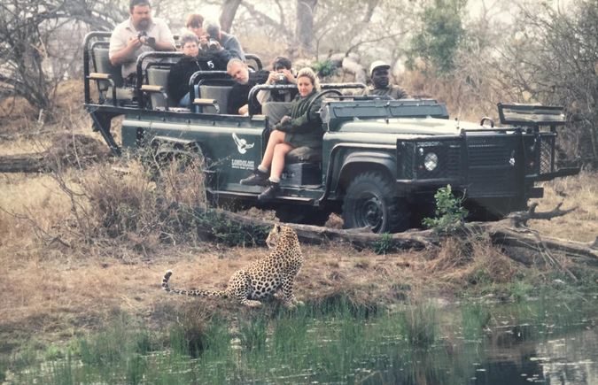 Leopard with safari vehicle and guests