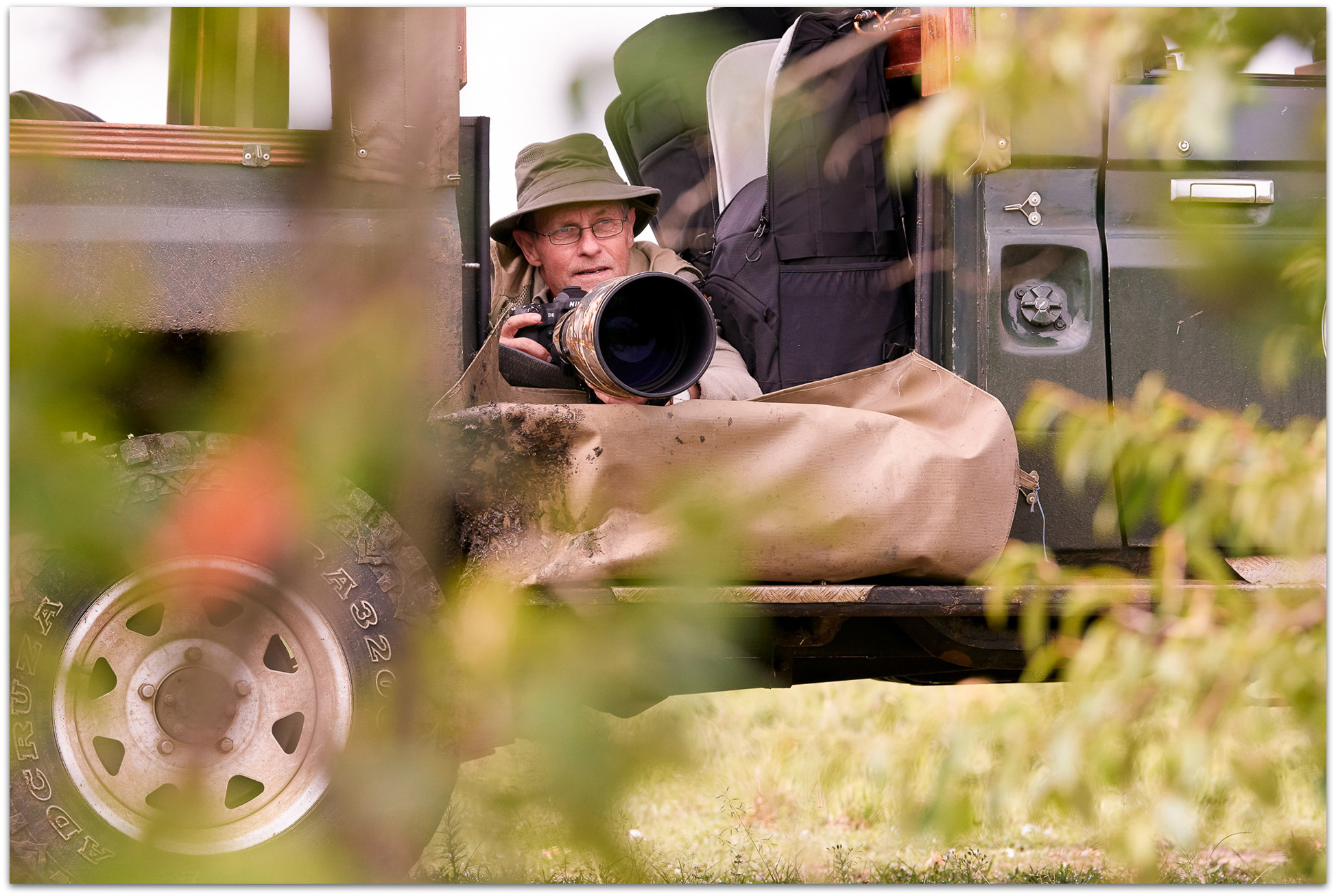 Photographer taking photos from a specially-adapted photographic safari vehicle