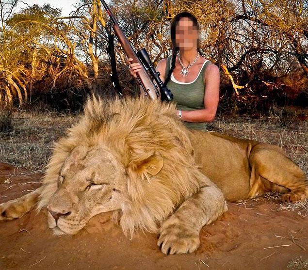 Hunter with dead lion, trophy hunting