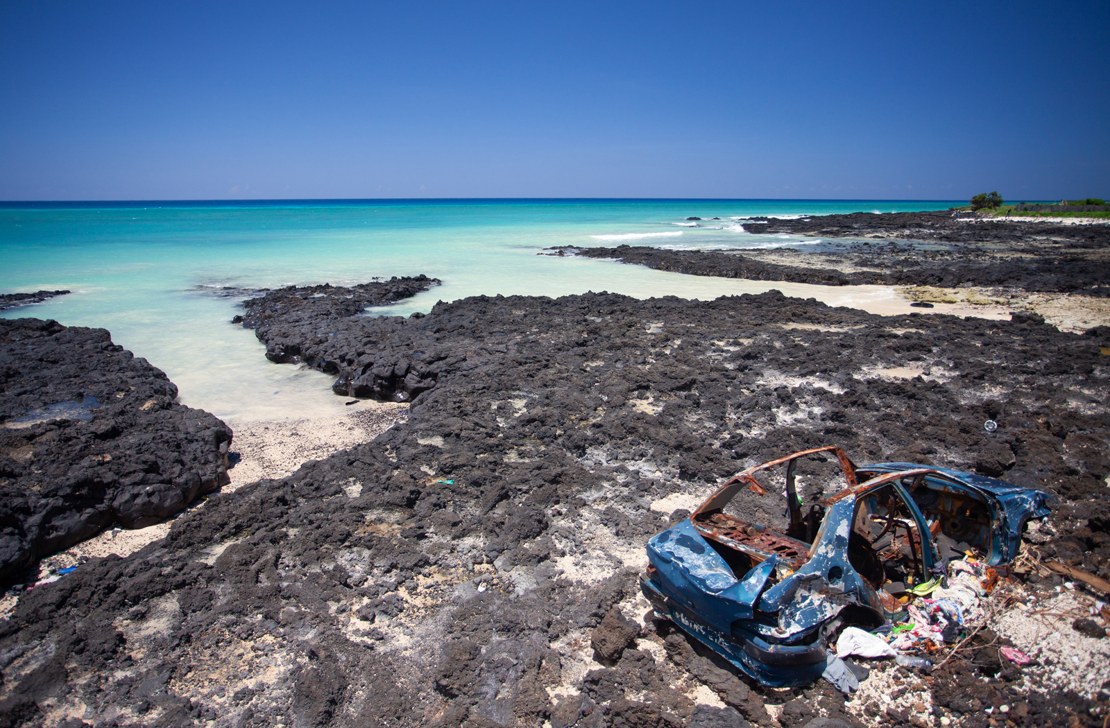 Abandoned car along the shoreline in Grande Comore