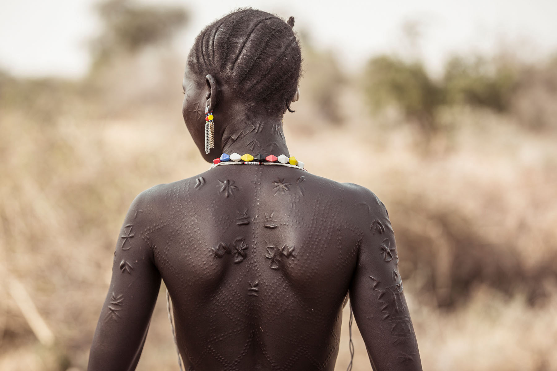 Scarification plays a huge role in tribal life, and is used as a way to distinguish between tribes and show the progression from childhood to adulthood. Here, a Boya girl shows off her scarifications © Joe Buergi