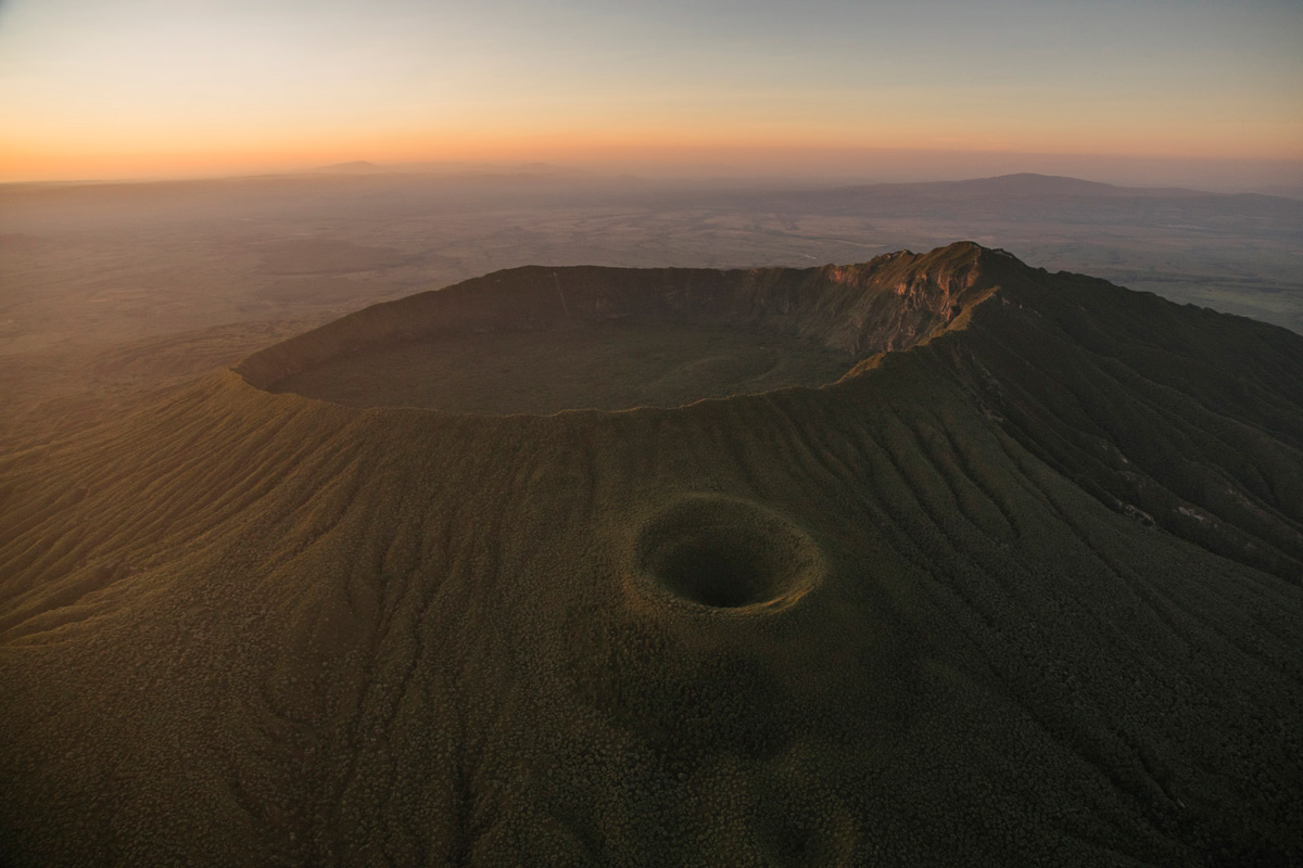 "Mount Longonot, a dormant stratovolcano, is green after a few weeks worth of rain. On the side of the main cone is a parasitic cone. These are formed when fractures exist along the side of the main cone. Eventually, those fractures reach the magma chamber and cause an eruption on the side of the main volcano and form what is called a parasitic cone. " – Great Rift Valley, Kenya © Bobby Neptune