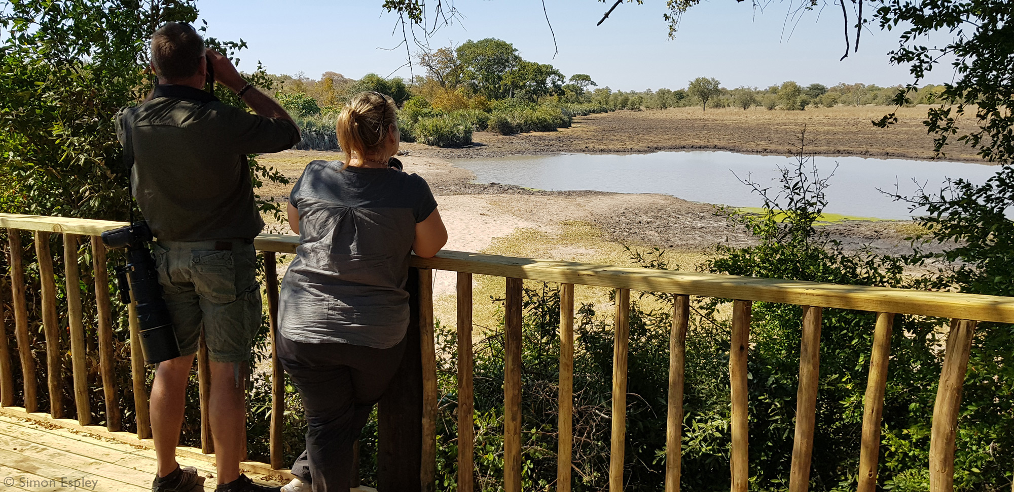 Two people viewing wildlife at Malugwe Pan, Zimbabwe