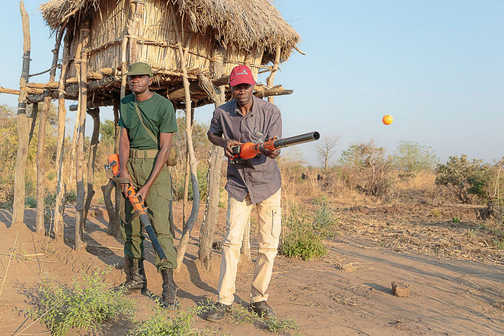 Two men demonstrating the chilli blaster to ward off elephants